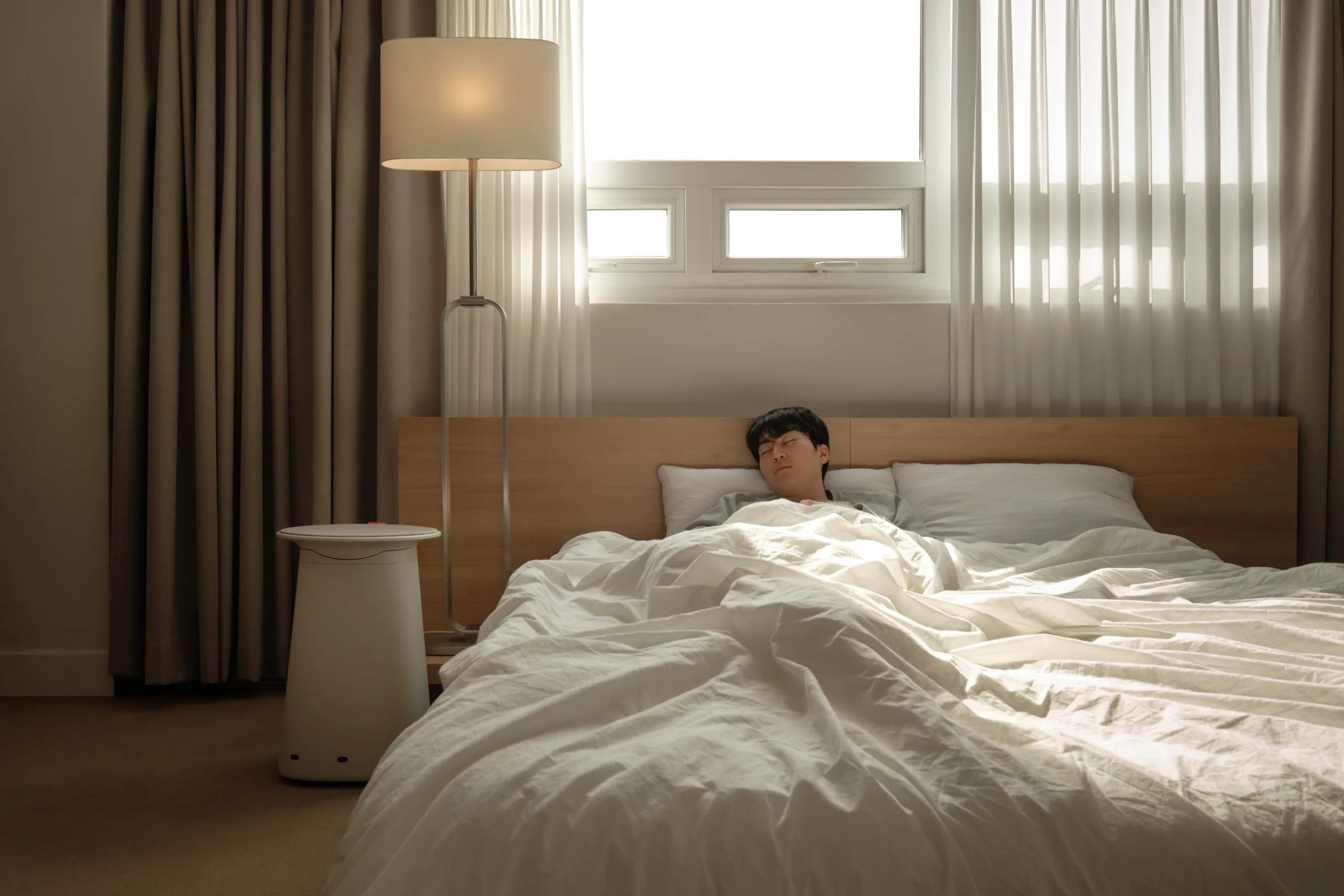 Cor! resting beside a bed while a person sleeps