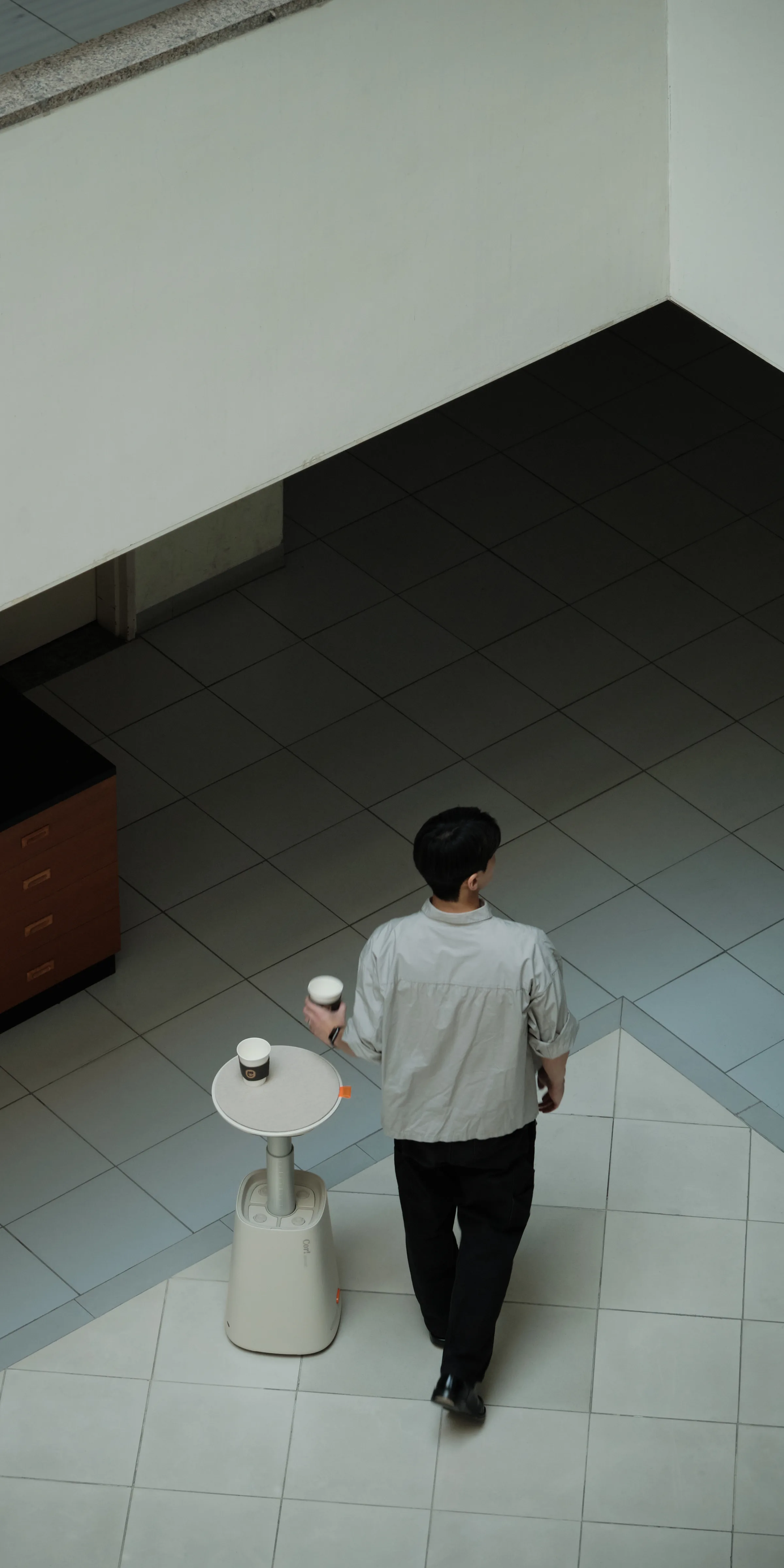 Cor! accompanying a person and carrying drinks through an interior space