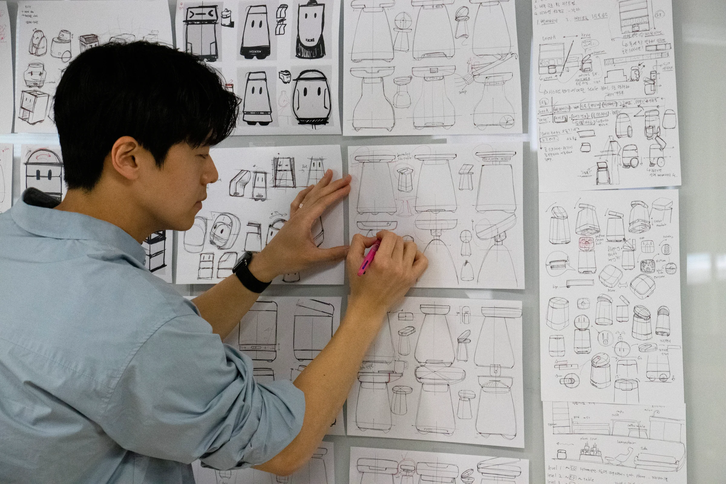 Designer reviewing early Cor! ideation sketches on a wall