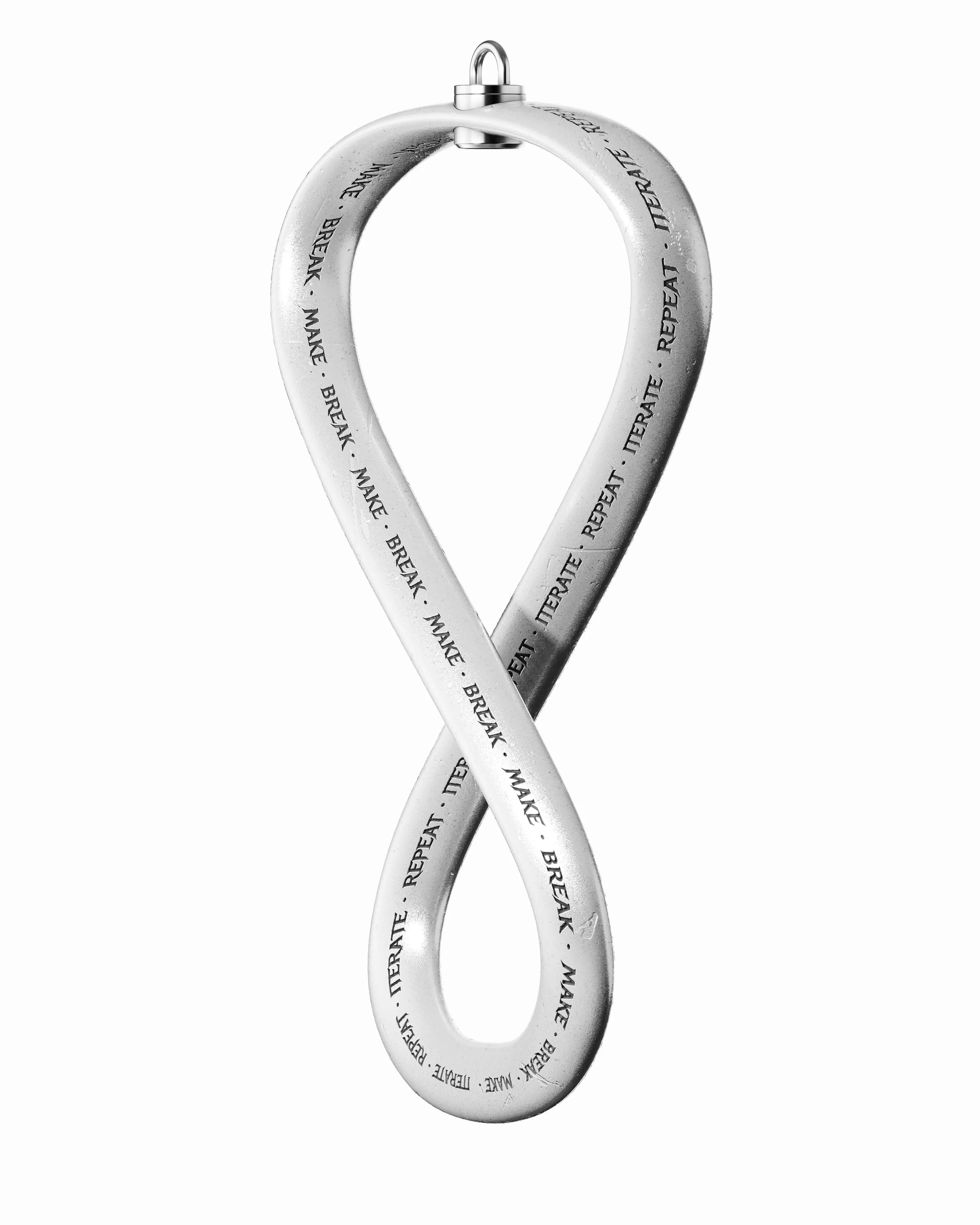 Isolated worn silver Möbius loop engraved with Make, Break, Iterate and Repeat